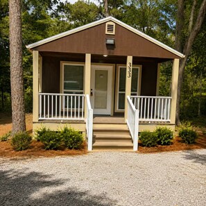 A small, single-story cabin with a front door, two white railings, and a number '333' on the door. - Luxury Cozy  1-bedroom house in Quitman with AC (Quitman)