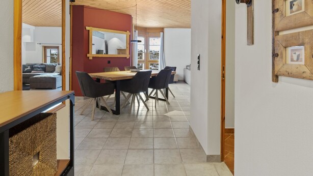 Un interior moderno con comedor, techo de madera y vistas al exterior.