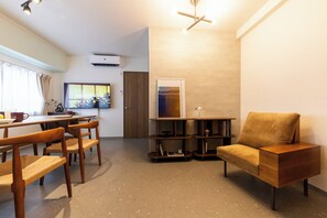 A modern living room with a sofa, a dining table with chairs, a TV, and a bookshelf. - June 2025 open! 3LDK/ Center of Shinsaibashi, Go Namba! (大阪市西区北堀江１丁目)