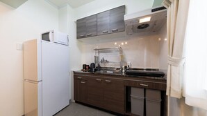 A compact kitchen with a refrigerator, microwave, and a sink area.
