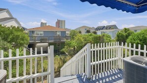 A residential area with houses, a white picket fence, and a blue awning. - Cherry Grove Coastal Escape · 2BR · Steps to Beach (North Myrtle Beach)