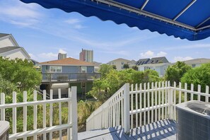 A residential area with houses, a white picket fence, and a blue awning.