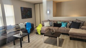 A living room with two sofas, a coffee table, and a decorative wall piece. - Luxury and spacious 4-bedroom house in adorable San Antonio with AC (San Antonio)