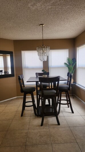 A dining area with a chandelier, a round table, and four chairs. - Luxury and spacious 4-bedroom house in adorable San Antonio with AC (San Antonio)
