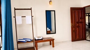 A room with a wooden bench, a wall-mounted mirror, a wooden door, and a blue curtain. - Luxury 5BR Family Villa Near Airport, Pool, Rooftop, Sleeps 14+ (Pansilgoda)