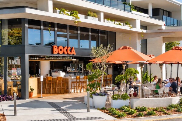 A restaurant named 'BOCCA' with outdoor seating and a modern architectural design.