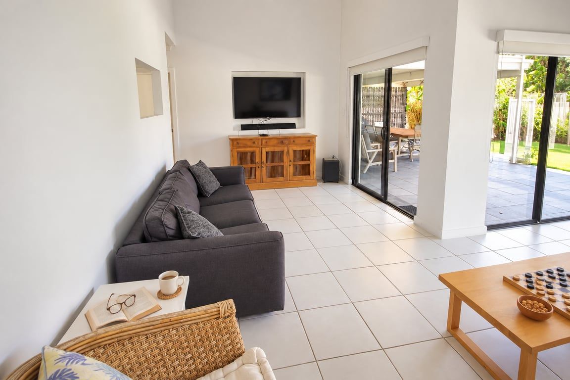 A modern living room with a sofa, a television, a coffee table, and a chess set.