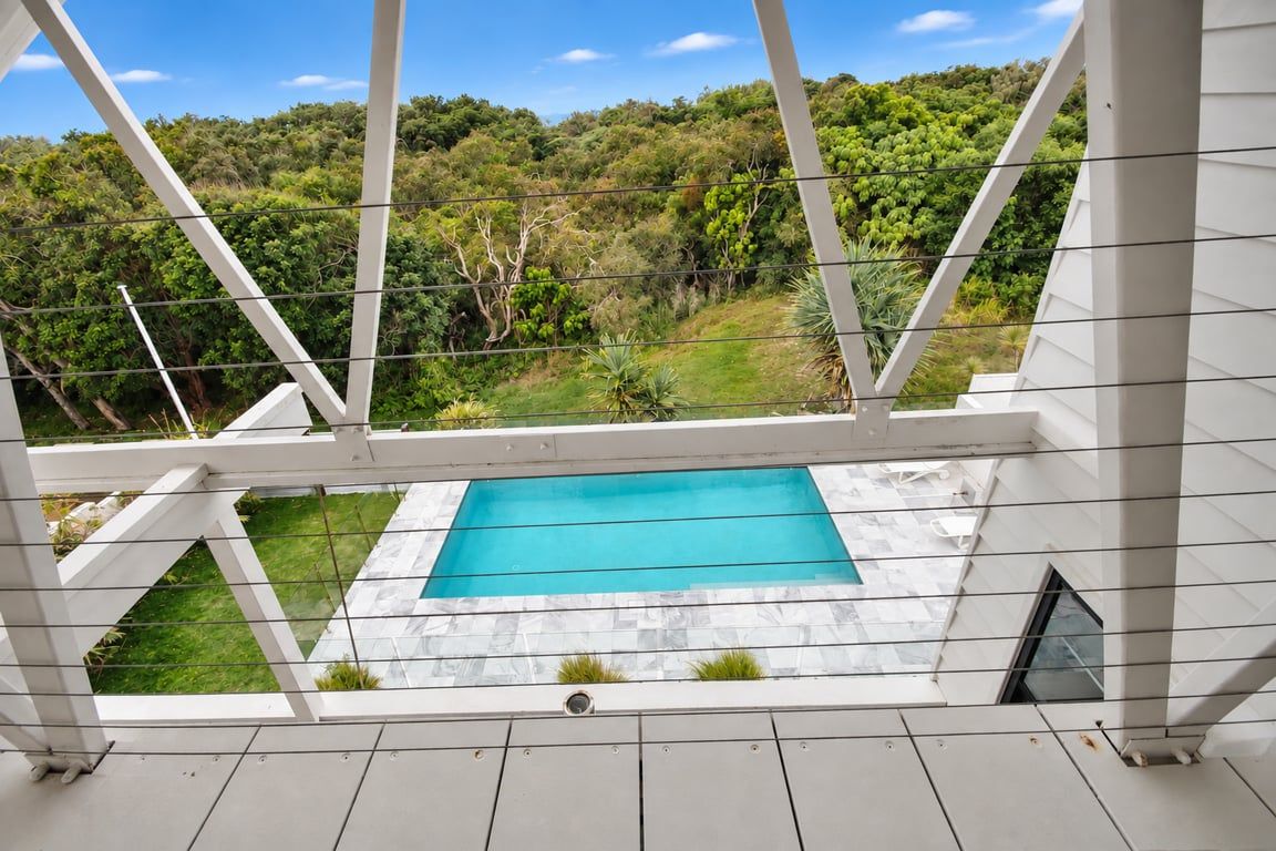 A pool area with a view of a lush green landscape.