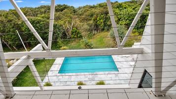 A pool area with a view of a lush green landscape.
