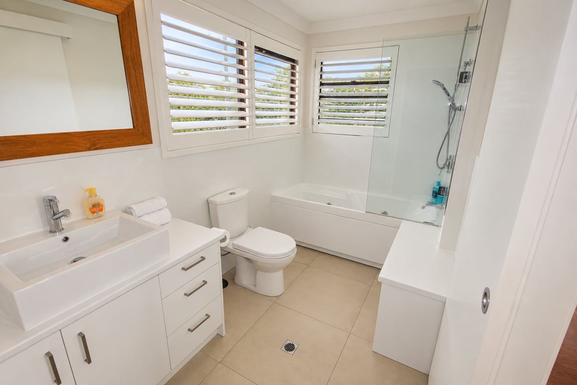 A modern bathroom with a white sink, toilet, and bathtub.