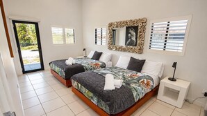 Habitación doble con dos camas, un espejo grande y una mesita de noche pequeña.