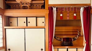Una habitación japonesa tradicional con suelo de tatami, paneles shoji y una cama futón.