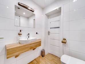 A modern bathroom with a white sink, wooden vanity, and a toilet. - Apartament nr 31 by Interhome (Gliwice)