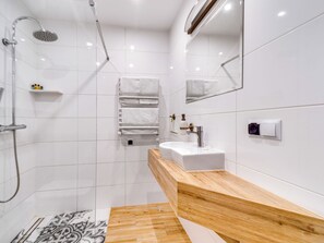 Ein modernes Badezimmer mit Dusche, Waschbecken und Spiegel.