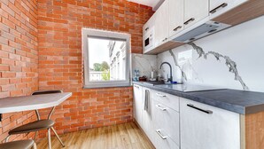 Una cucina con parete in mattoni, finestra, lavello e mobili.