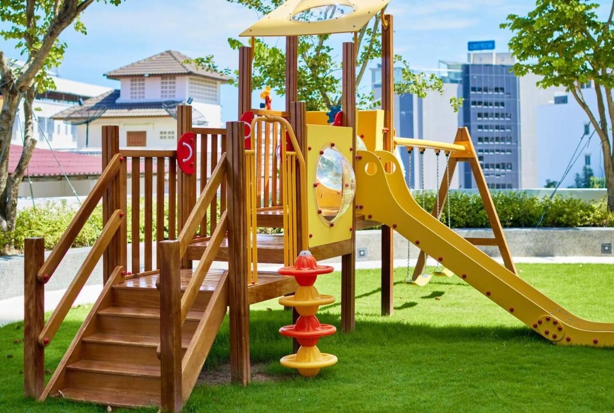 A playground with wooden steps, a slide, and a climbing structure.