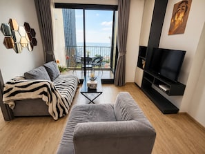 Una sala de estar moderna con un sofá, un sillón y un televisor de pantalla plana.