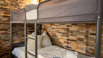 A bunk bed with a headboard, pillows, and a book on the lower bunk.