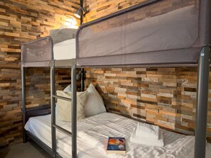 A bunk bed with a headboard, pillows, and a book on the lower bunk. - Cozy holiday apartment by a lake in Carinthia (Hermagor-Pressegger See)