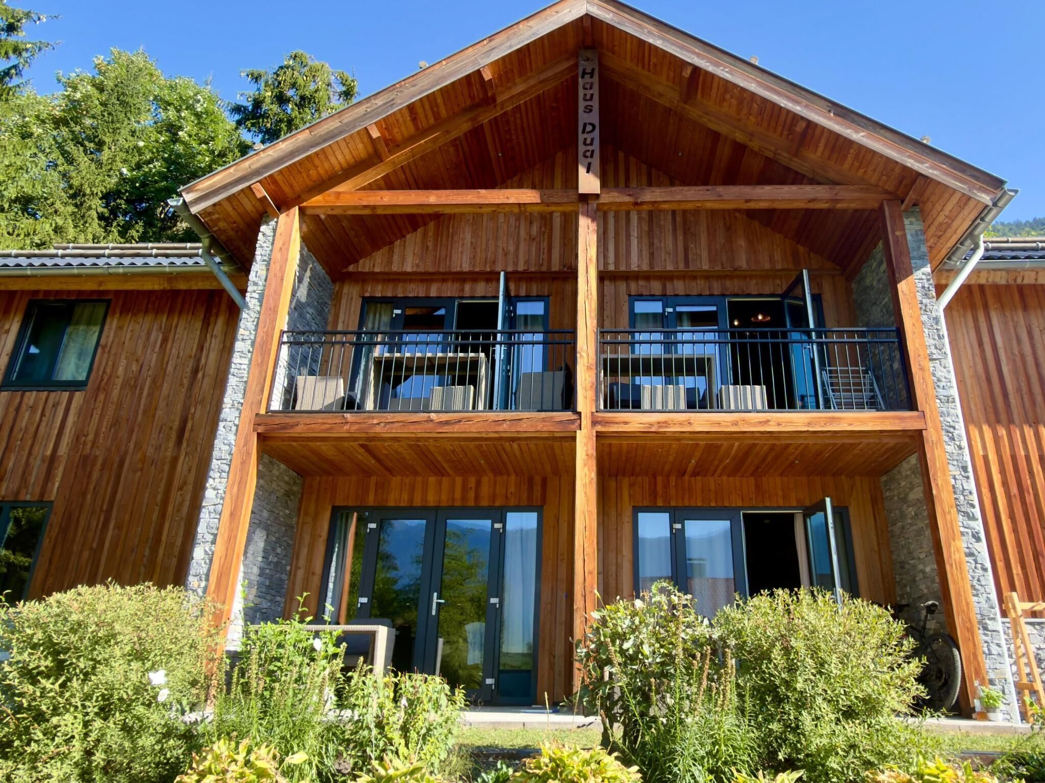 A two-story wooden building with balconies and large windows.