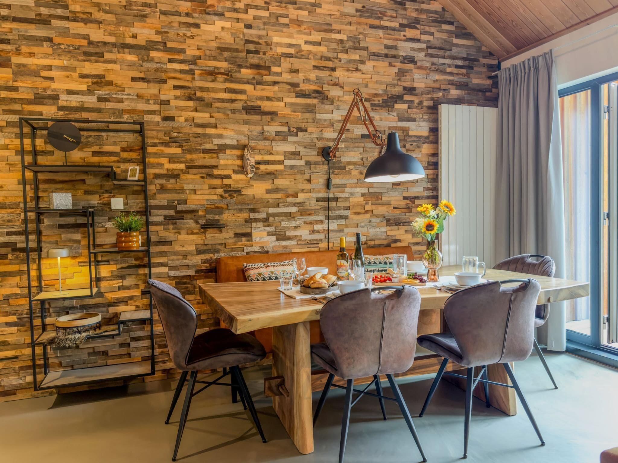 A dining area with a wooden table, four chairs, and a hanging pendant light.