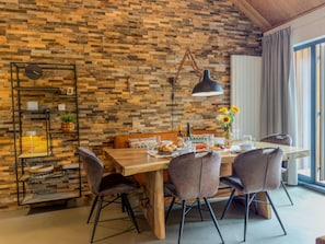Un comedor con una mesa de madera, cuatro sillas y una lámpara colgante.
