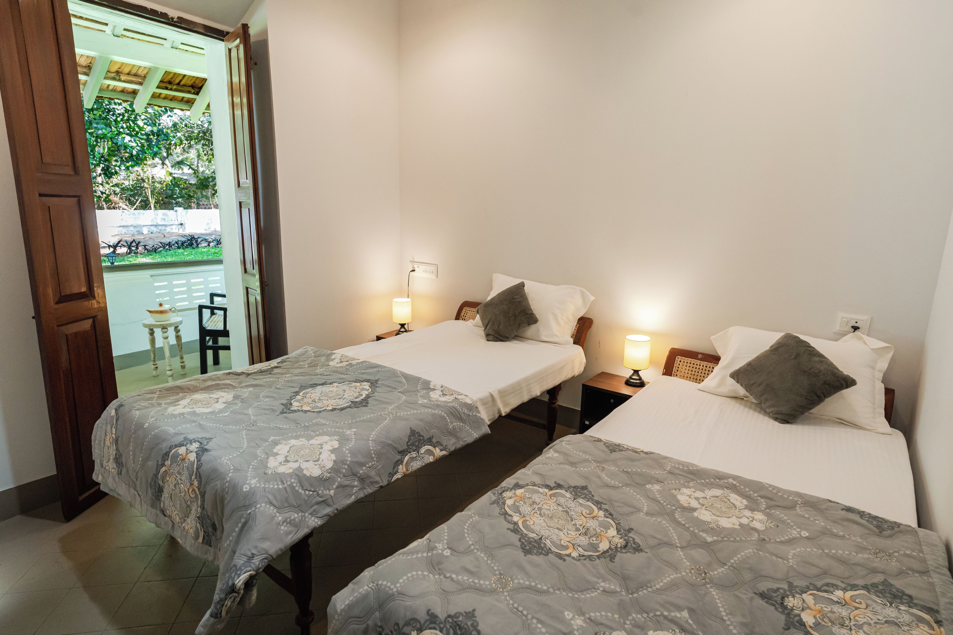 Une chambre d’hôtel avec deux lits simples, chacun étant équipé d’un oreiller et d’une lampe de chevet.
