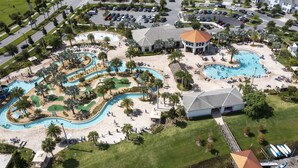 An aerial view of a resort with multiple swimming pools, a golf course, and a dock with boats. - 401 - Beyond the Sea & Into the Stars (Kissimmee)