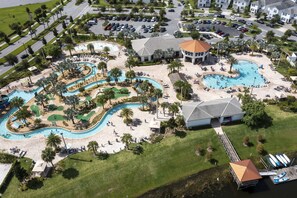 An aerial view of a resort with multiple swimming pools, a golf course, and a dock with boats. - 401 - Beyond the Sea & Into the Stars (Kissimmee)