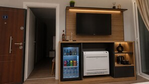 Ein Hotelzimmer mit Minibar, Fernseher und Kühlschrank.