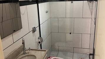 Regadera, secadora de cabello, toallas, papel de baño