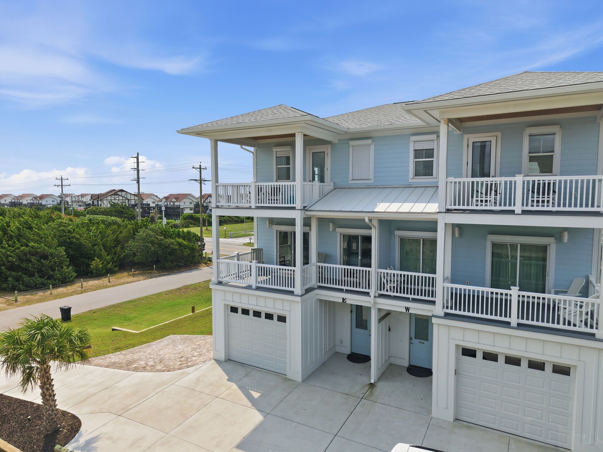 A multi-story residential building with a garage, balconies, and a driveway.