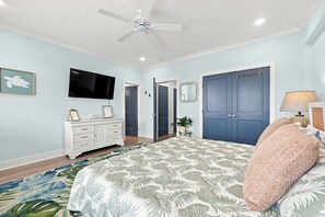 A bedroom with a bed, a ceiling fan, a dresser, a television, and a wardrobe. - Shore Perfection | Family Beach Retreat, Sleeps 8 (Emerald Isle)