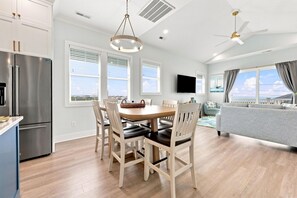 Une cuisine moderne avec un coin repas, un téléviseur à écran plat et une vue sur la mer.