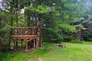 A wooden deck structure in a forested area with a rope ladder. - The Carrock, a secluded retreat near 81/77 (Max Meadows)