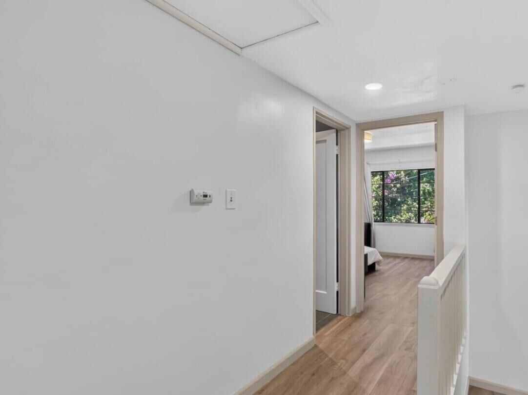 A hallway with a door leading to a balcony with a view.