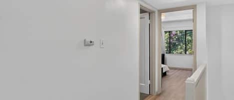 Un pasillo con una puerta que da a un balcón con vistas.
