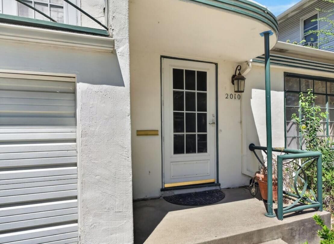 A house with a white door, a garage door, and a number '2010' on the wall.