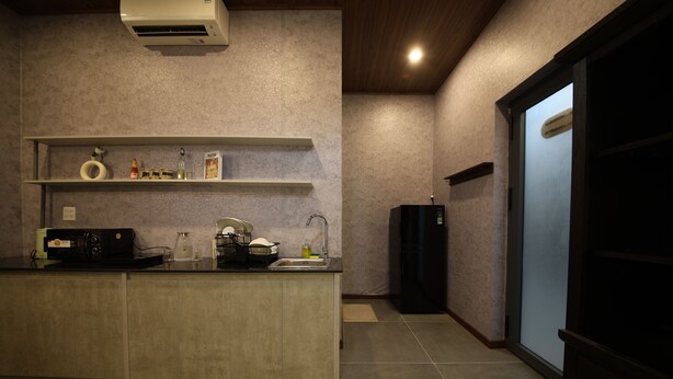 A kitchen with a built-in microwave, a sink, and a refrigerator. - Ala Homestay Can Tho - Vincom Xuan Khanh (Can Tho)
