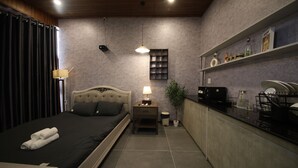 A bedroom with a bed, bedside table, lamp, and a small plant. - Ala Homestay Can Tho - Vincom Xuan Khanh (Can Tho)