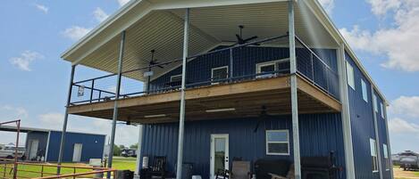 A two-story building with a covered balcony and a garage.