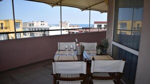 A balcony with a table set for two, a bottle of champagne, and a potted plant. - Hotel Sveti Nikolai (Primorsko)
