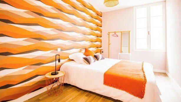 A bedroom with a bed, a bedside table, a lamp, a hanging light fixture, and a window. - "Côté sauvage" 4-star vacation rental for 16 people (La Tremblade)