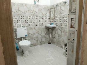 A bathroom with a toilet, sink, and shower. - Kashi Ghat Haven Homestay (Varanasi)