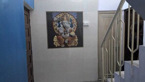 A staircase with a metal railing and a wall-mounted religious mural. - Kashi Ghat Haven Homestay (Varanasi)