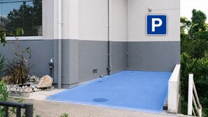 Un edificio con una zona de estacionamiento azul y un letrero azul de estacionamiento.