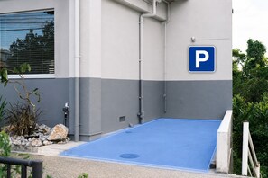 A building with a blue parking area and a blue parking sign.