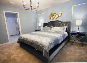 Un dormitorio con una cama grande, mesitas de noche, un candelabro y una lámpara de pared.
