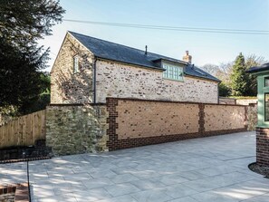 A stone building with a tiled driveway and a brick wall. - Suncrest Cottage - UKC9942 (Weymouth)