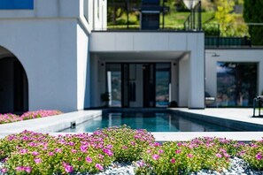 Un edificio moderno con piscina y parterres de flores.